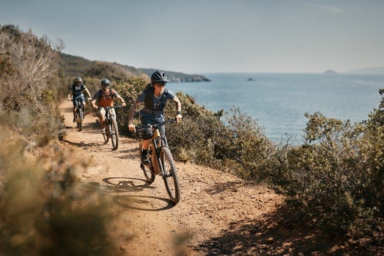 Pedalling on our e-MTBs along Piombino's coast with the sea on our left on a sun-baked singletrack trail
