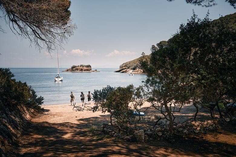 Walking barefoot on a secret Elba Island beach after a bike ride