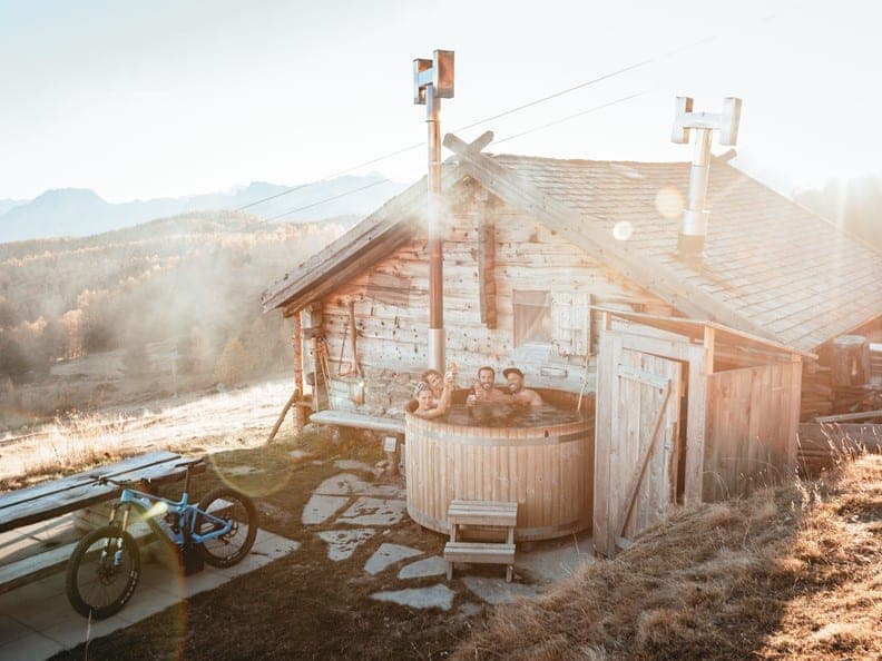 Four riders in a hot tub at the Moosalp Mountain Hut