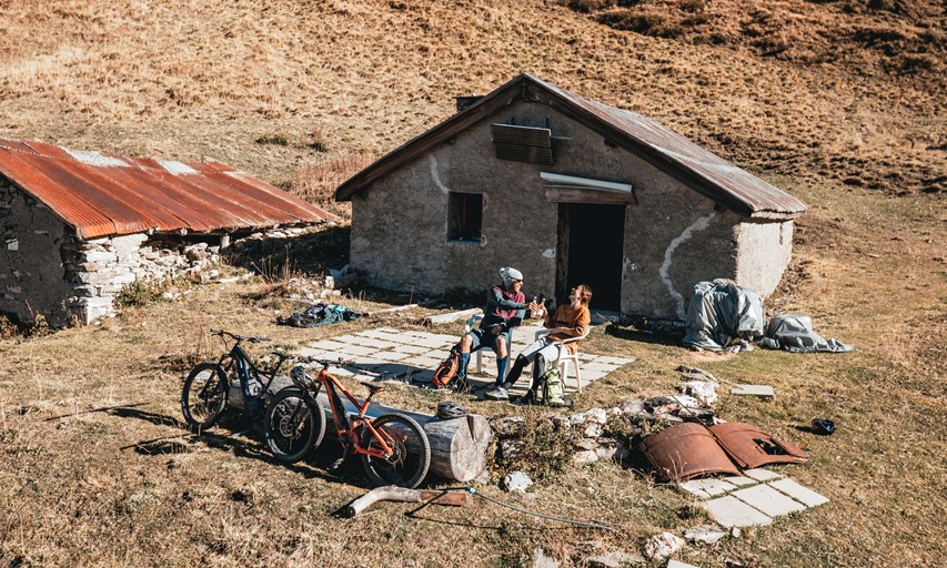 Two riders taking a well deserved break at a mountain hut after a full day on the bike on the haute route